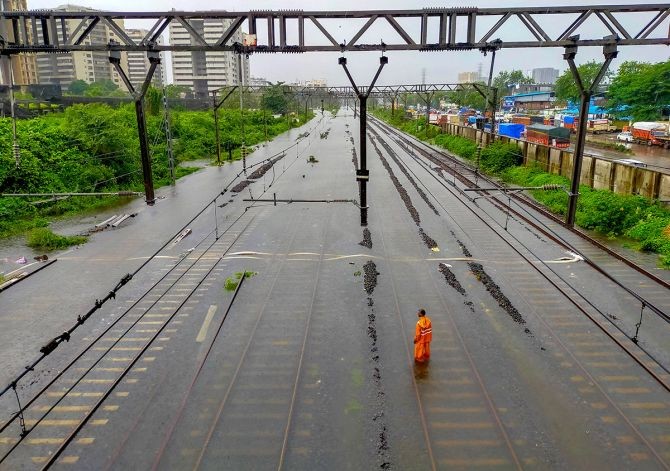 A man stands on waterlogged railway tracks between Kurla and Sion in Mumbai. Photograph: PTI Photo